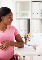 pregnant woman speaking to a doctor