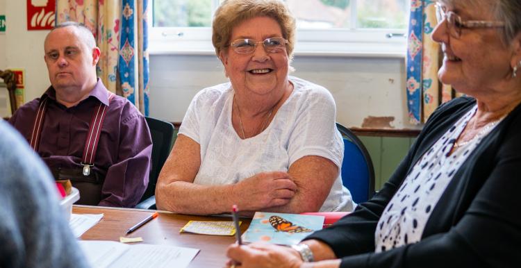 Women smiling at a community wellbeing group 