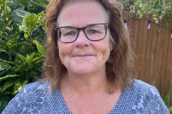 A picture of a woman named Patricia, who is Healthwatch Brent's Manager. She has short brown hair and is wearing a blue floral top and black glasses.